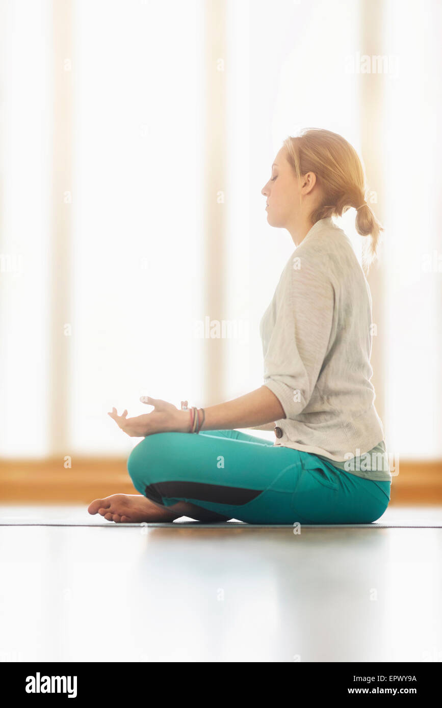 Woman meditating on floor Stock Photo
