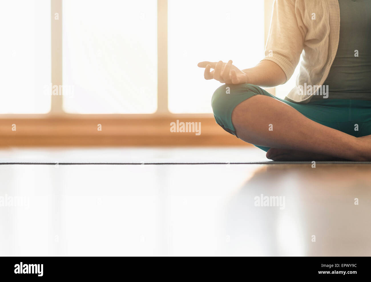 Woman meditating on floor Stock Photo - Alamy