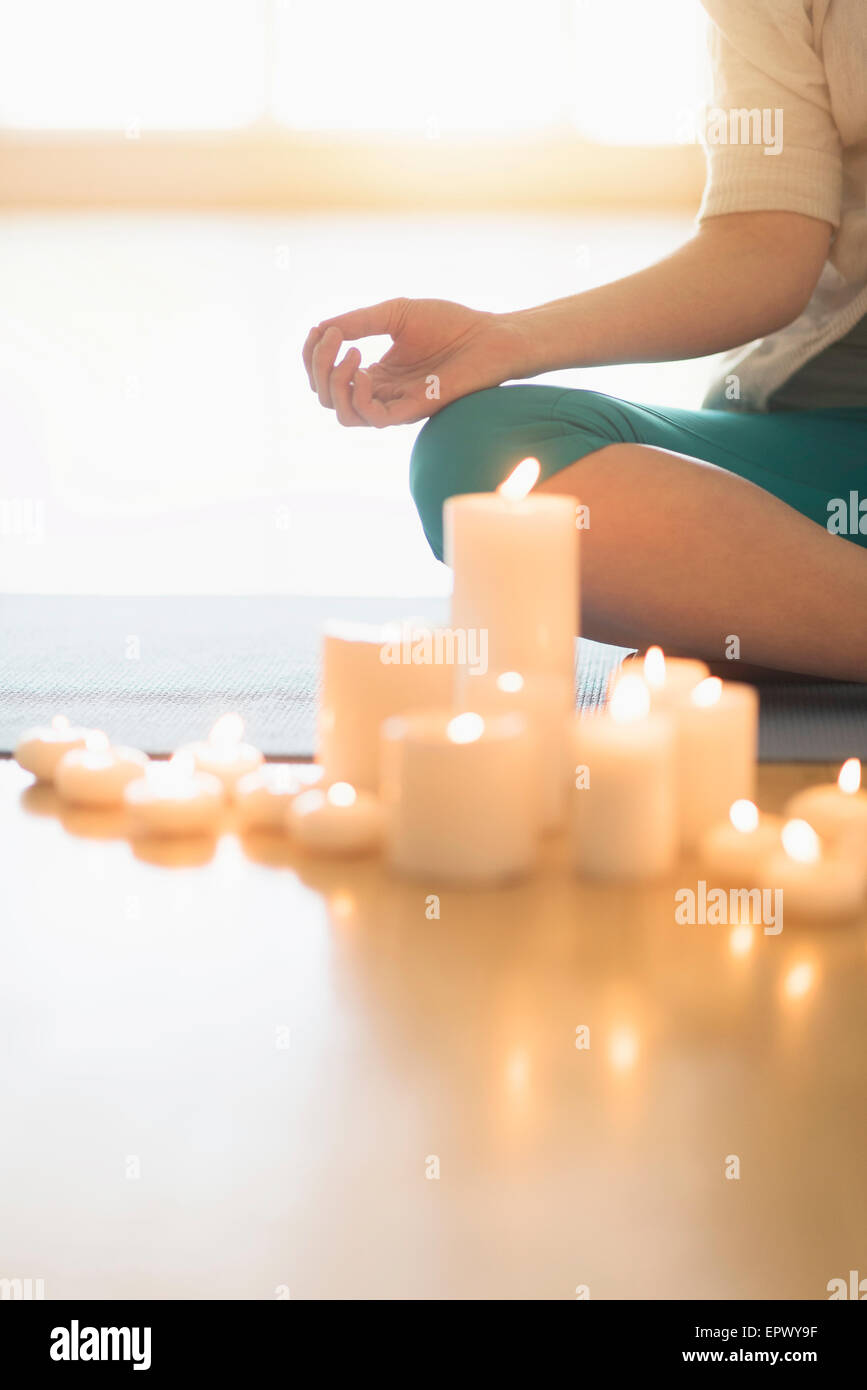 Woman meditating surrounded by candles Stock Photo