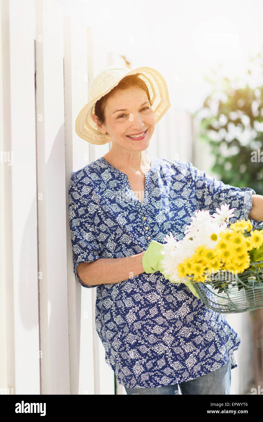 Portrait of smiling senior woman with flowers Stock Photo
