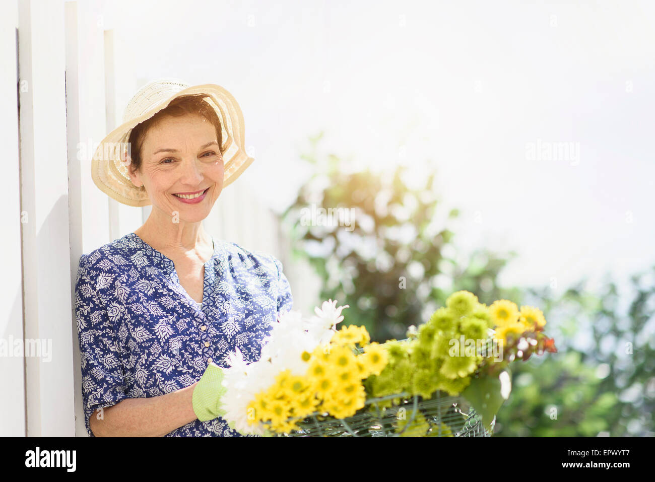 Portrait of smiling senior woman with flowers Stock Photo