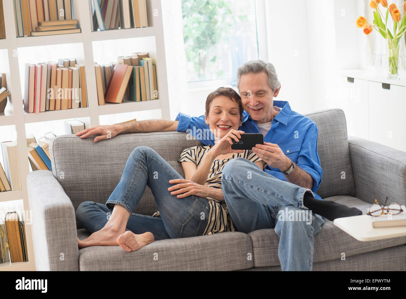 Senior couple sharing cell phone on sofa Stock Photo