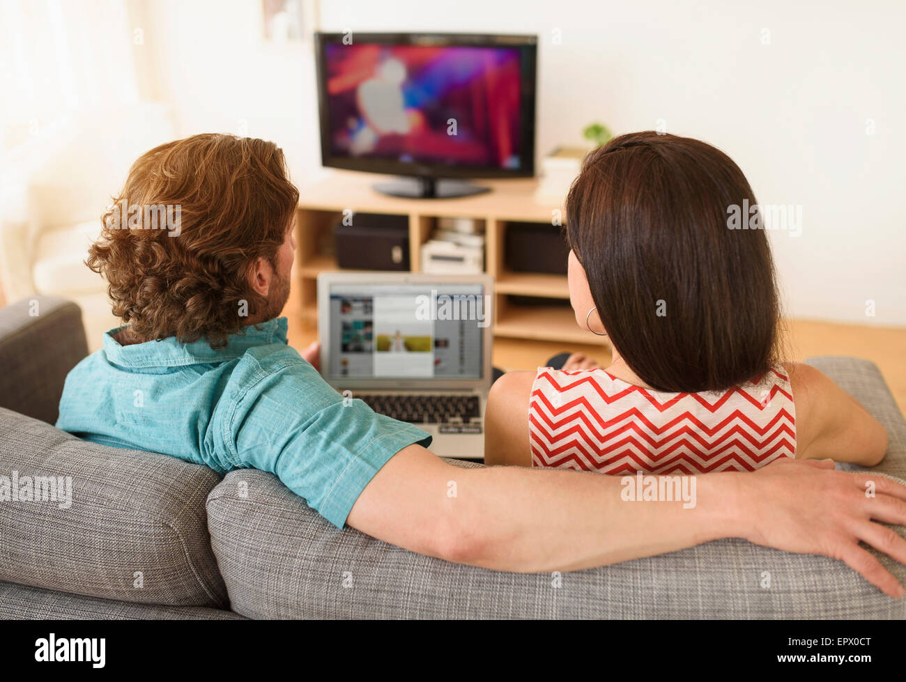 Couple using laptop on sofa Stock Photo - Alamy