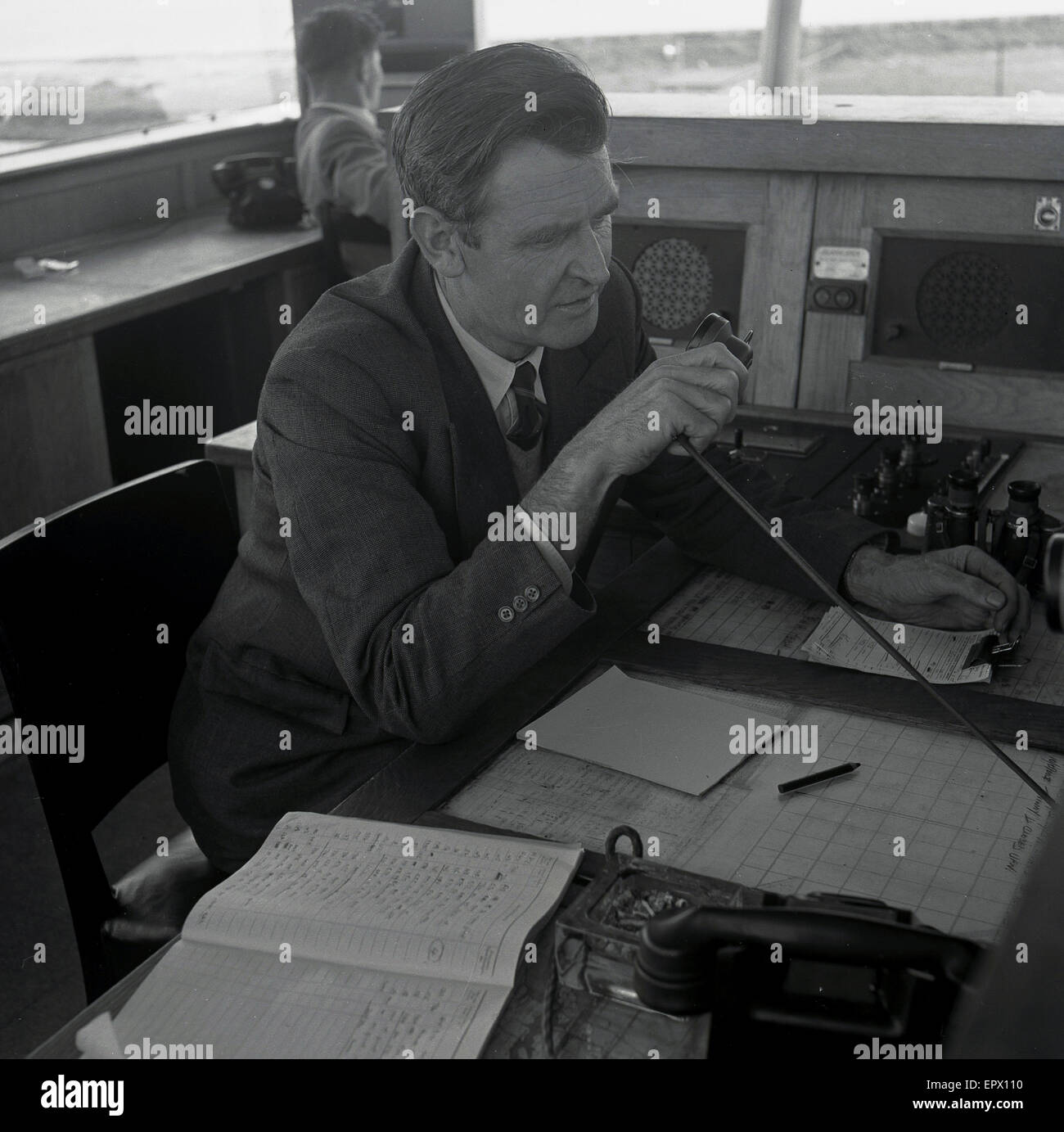 1950s, historical, a male air traffic controller talking to a pilot while at his desk in the airport control tower, Dublin, Ireland Stock Photo