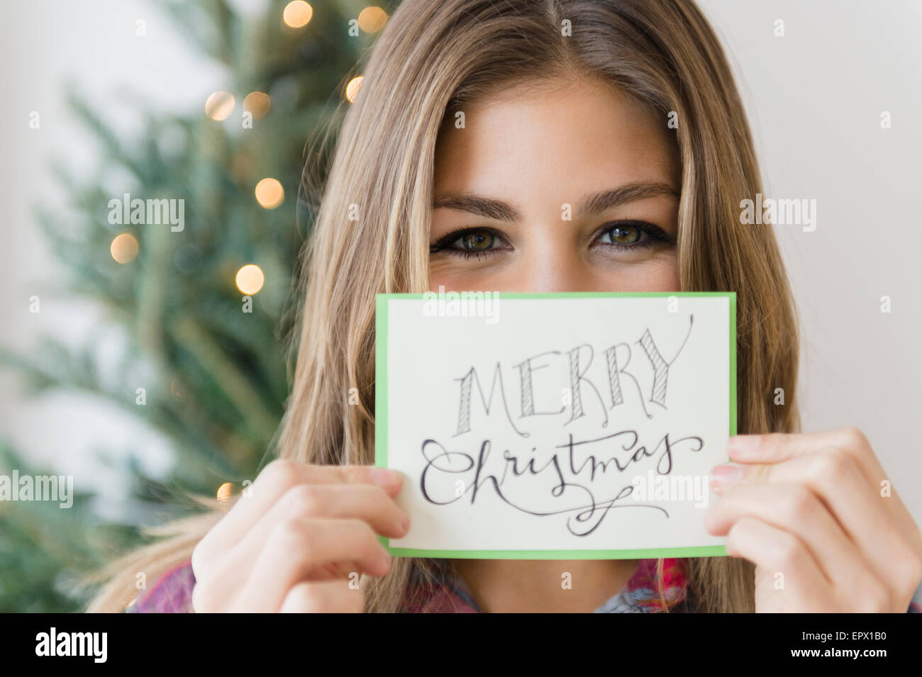 Young woman holding greeting card for christmas Stock Photo - Alamy