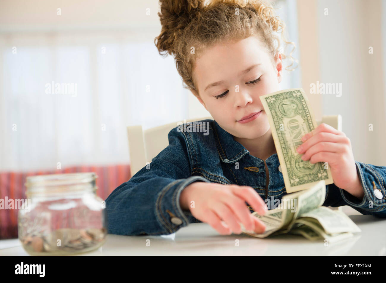 Girl (10-11) counting her savings Stock Photo
