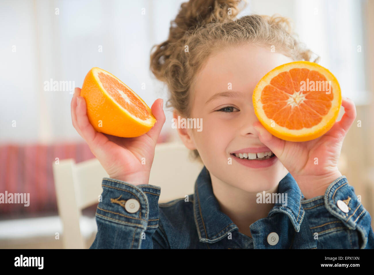 Girl (10-11) holding orange Stock Photo