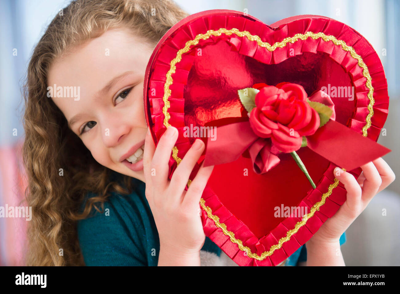 Portrait of girl (10-11) with heart-shaped chocolate box Stock Photo - Alamy