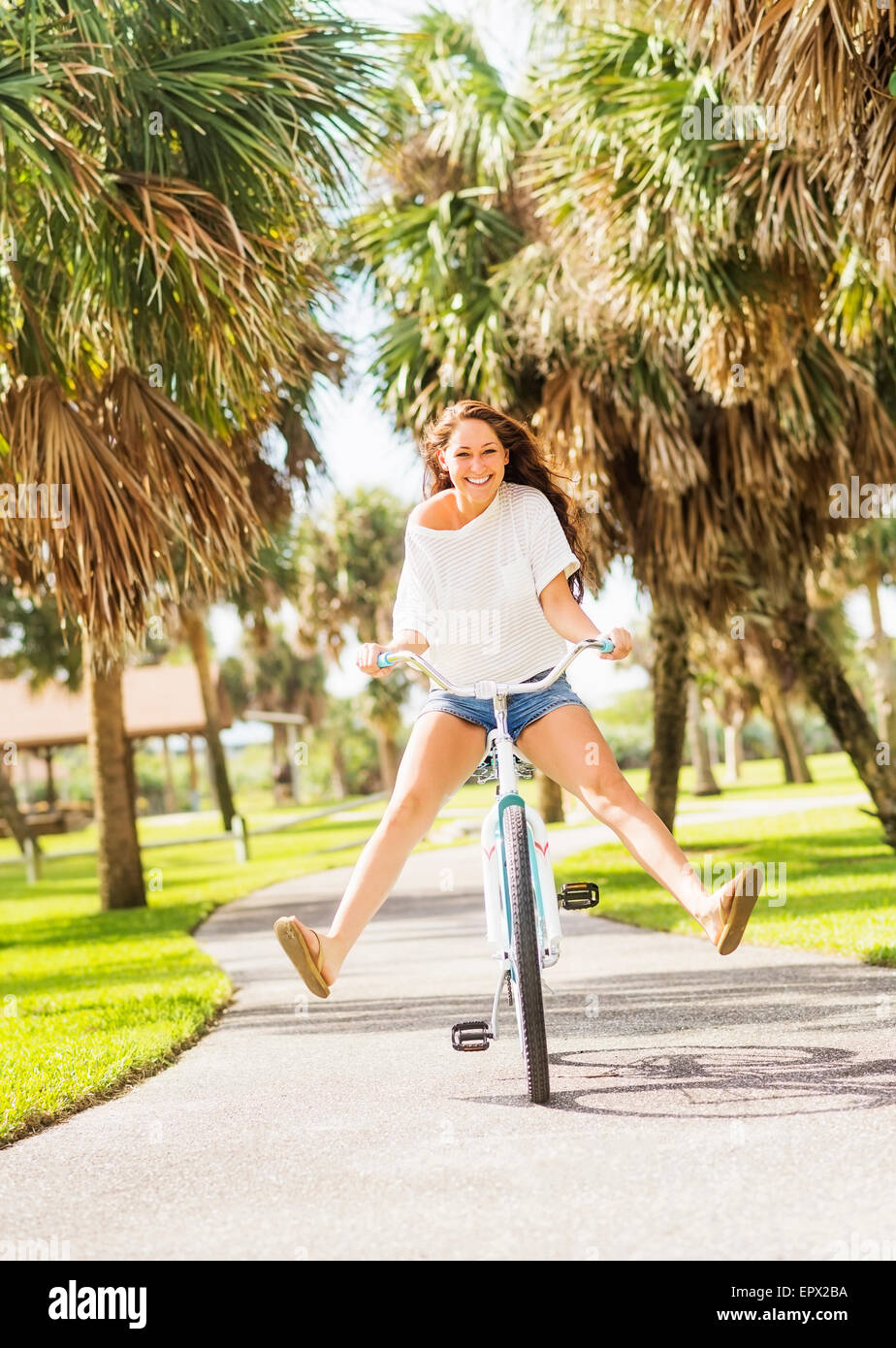 USA, Florida, Jupiter, Young woman riding bicycle in park Stock Photo