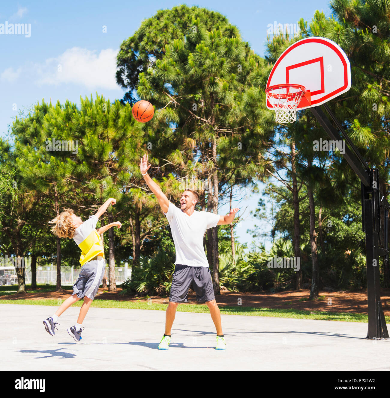 Boy (8-9) playing basketball with his brother Stock Photo