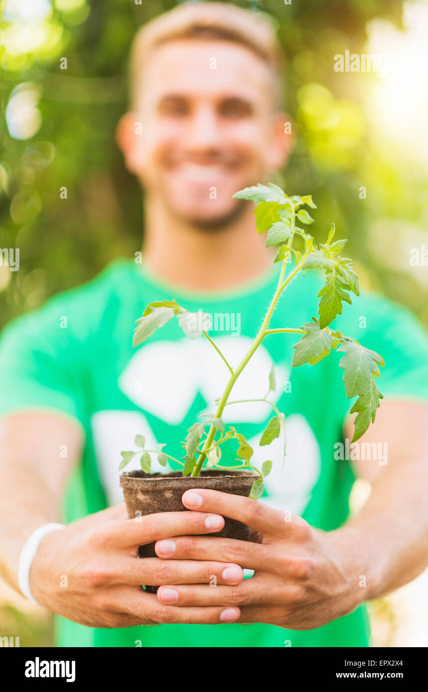 Portrait of young man holding potted plant Stock Photo - Alamy