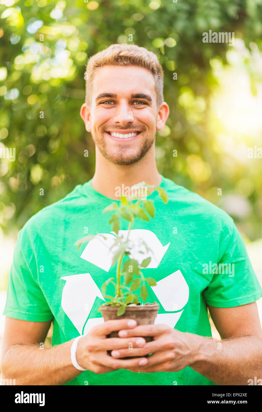 Portrait of young man holding potted plant Stock Photo - Alamy