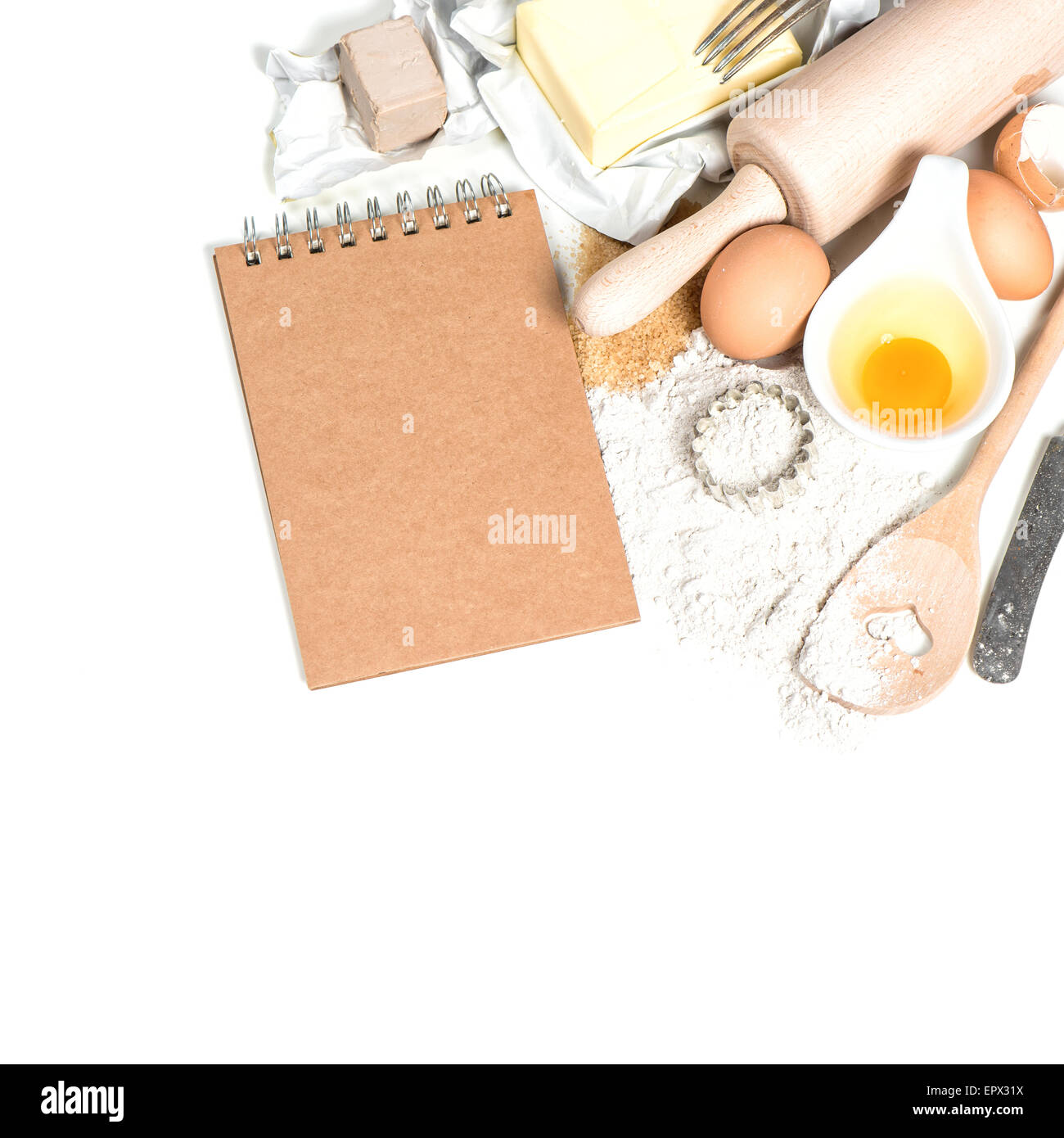 Baking ingredients eggs, flour, sugar, butter, yeast. Food background with recipe book Stock Photo