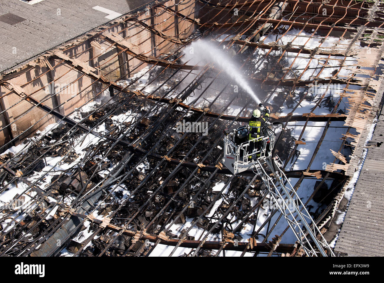 Cologne, Germany. 22nd May, 2015. A fireman sprays water on the ruins