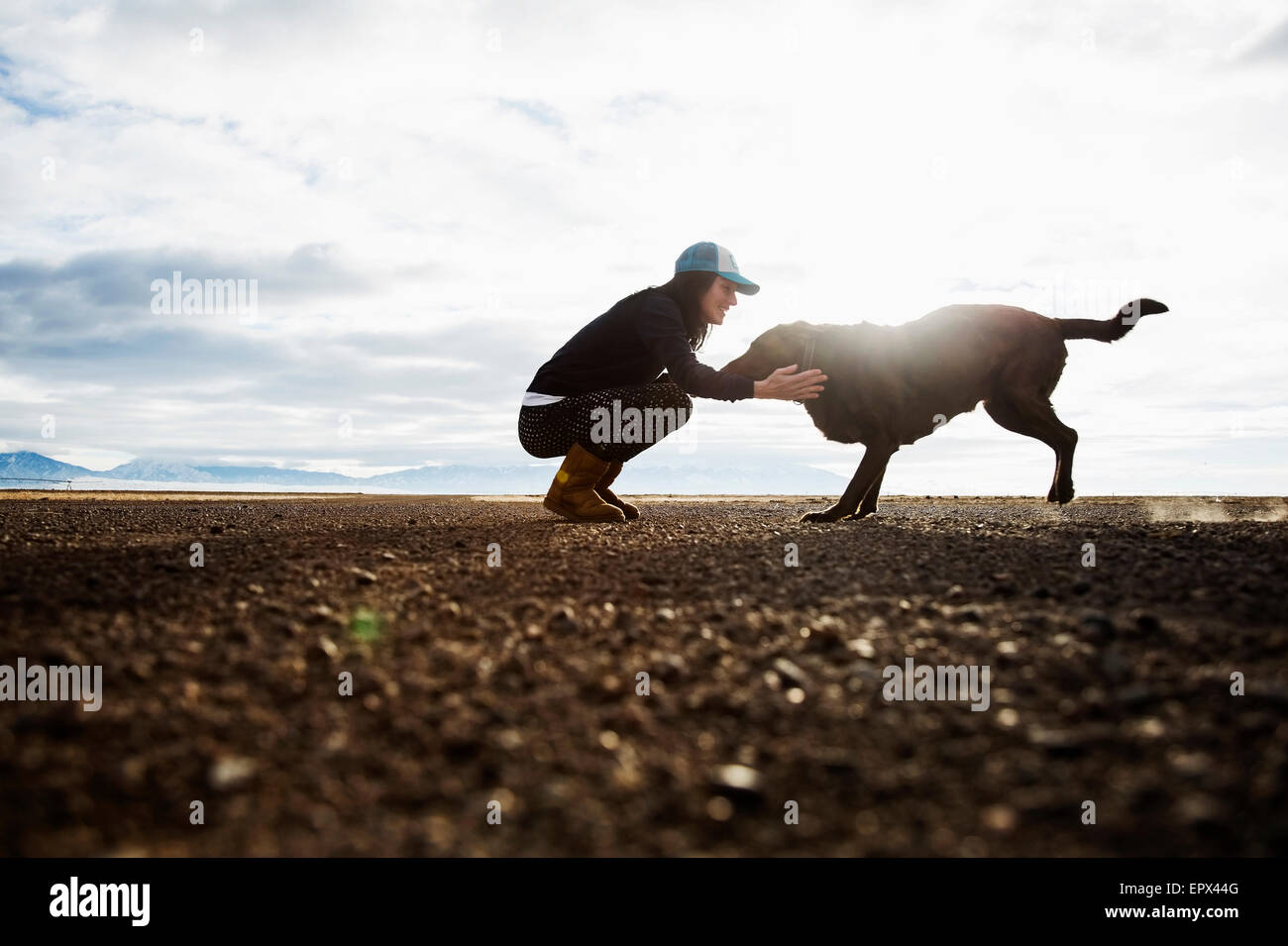 USA, Colorado, Woman with dog outdoors at sunrise Stock Photo