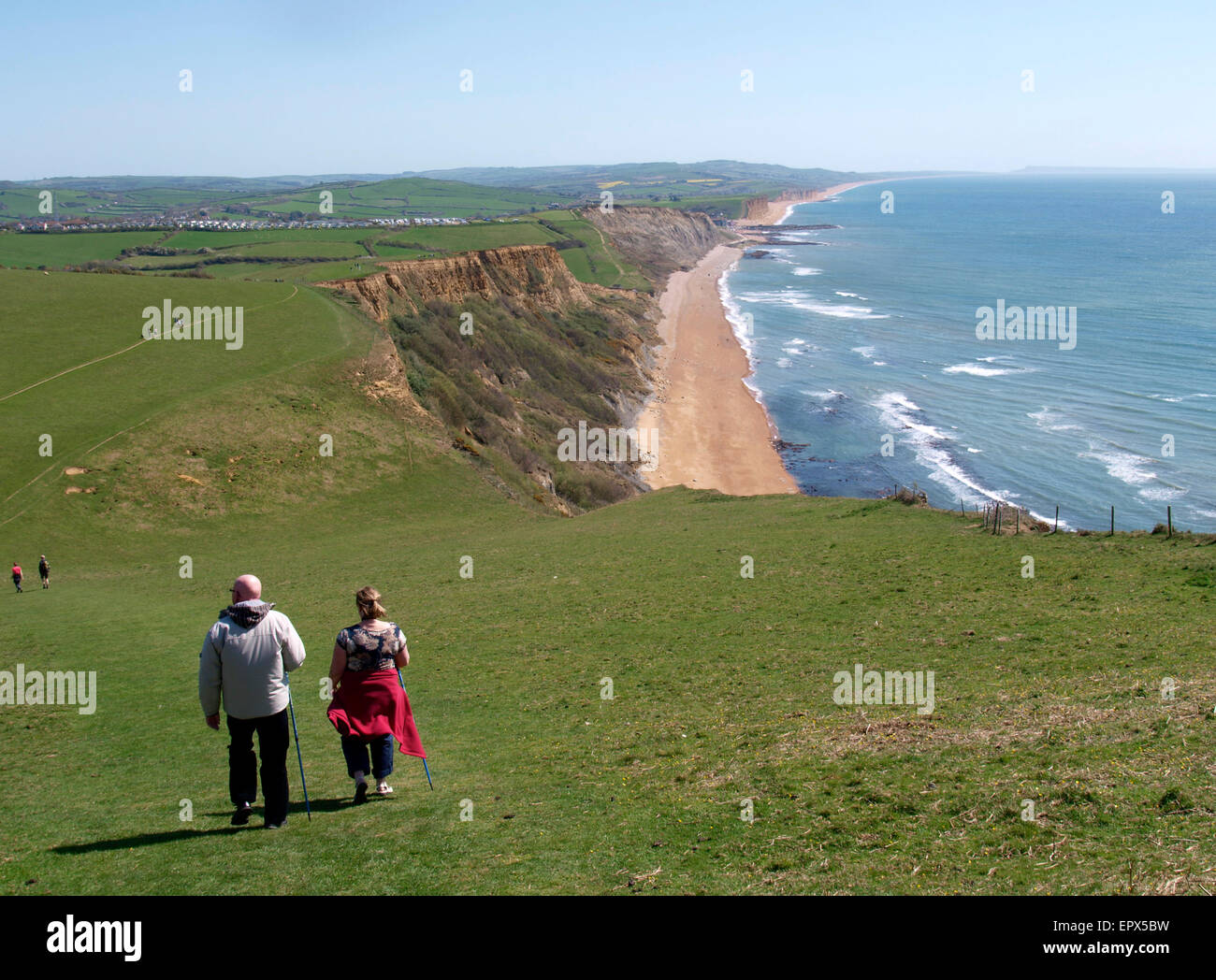 Walkers on the southwest coast path walking down Thorncombe Beacon hill towards Eype, Dorset, UK Stock Photo