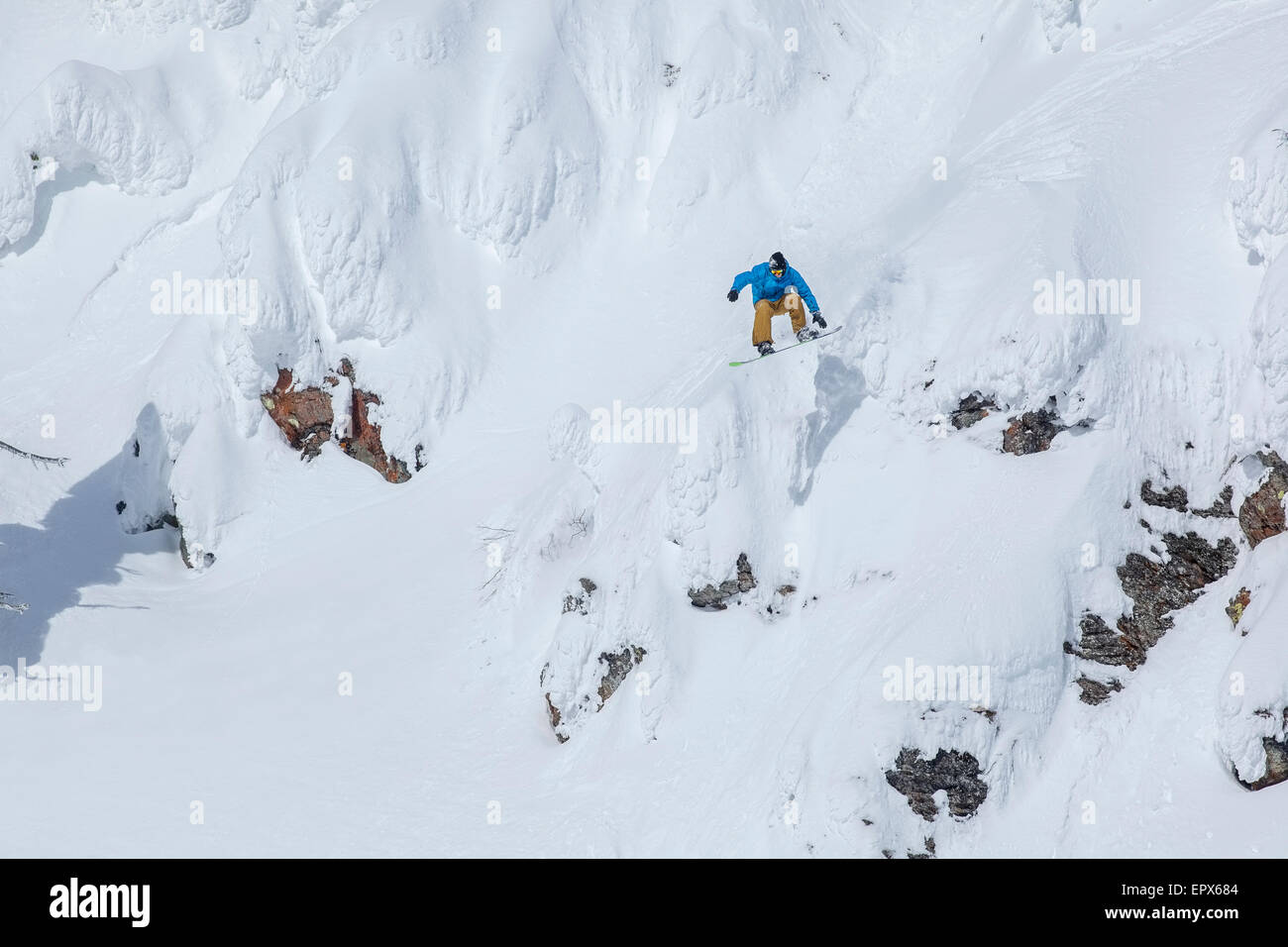 USA, Montana, Whitefish, Man snowboarding down mountain Stock Photo