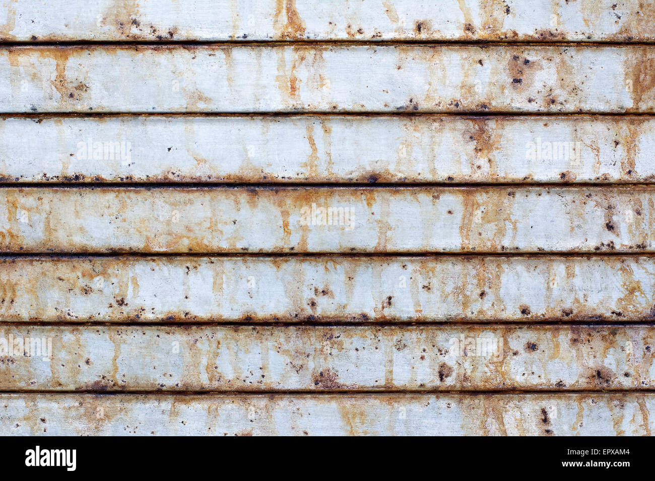 Close up of a rusted metal roll up door shows the damage that salty air near a port can cause. Stock Photo