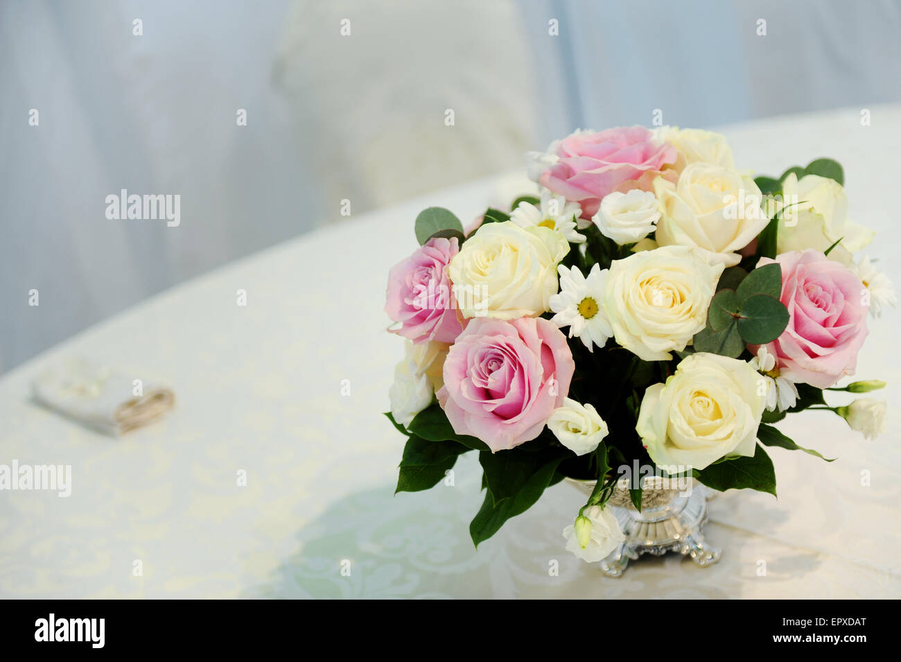 Wedding arrangement of a roses bouquet on a restaurant table Stock Photo