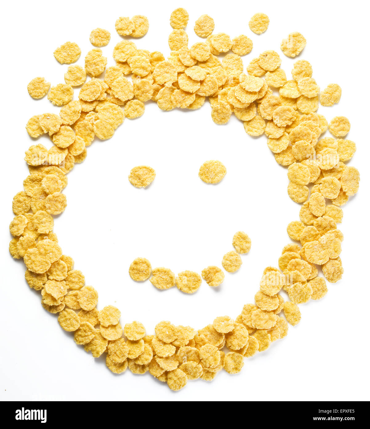 Cornflakes arranged as smiley face on a white background. Stock Photo