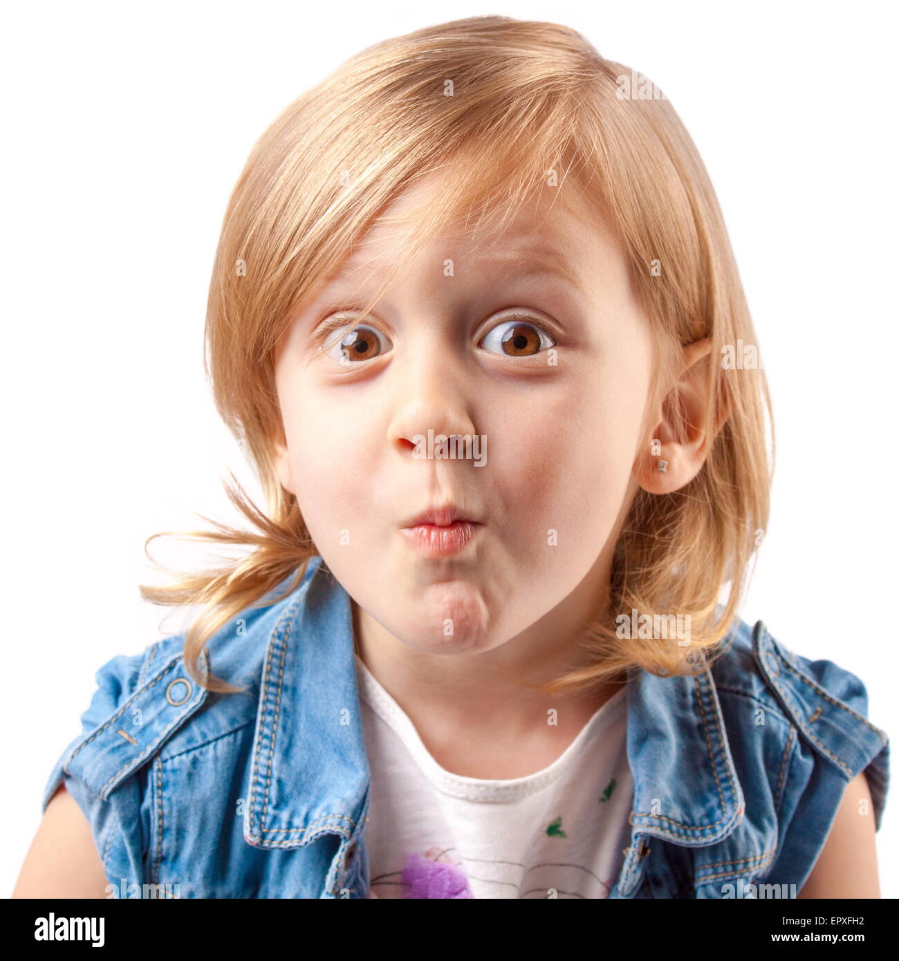 Little cute girl making grimace and having fun Stock Photo