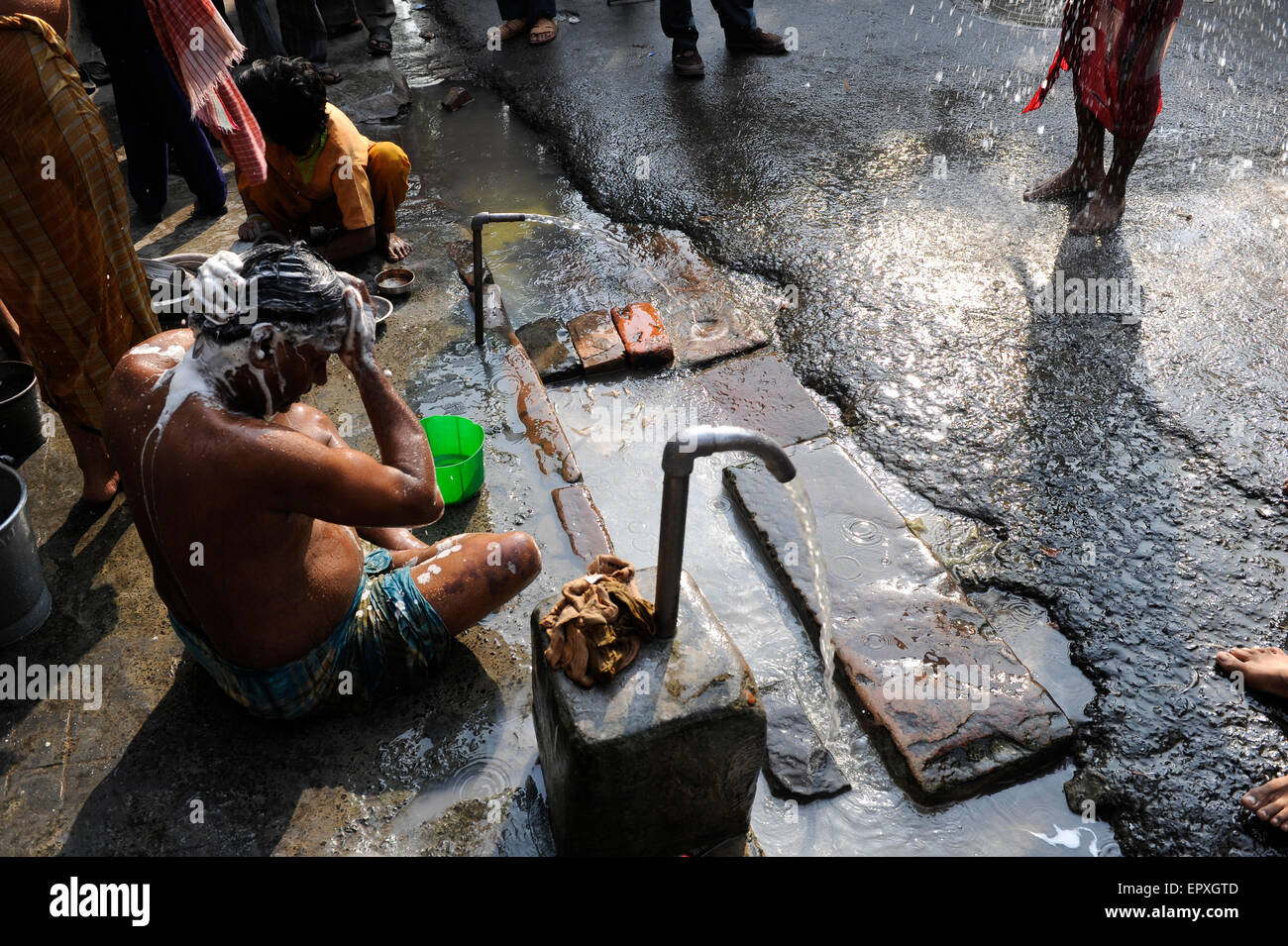 INDIA Westbengal Calcutta Kolkata, people take bath on the road/ INDIEN Westbengalen Megacity Kalkutta, Menschen waschen sich auf der Strasse Stock Photo