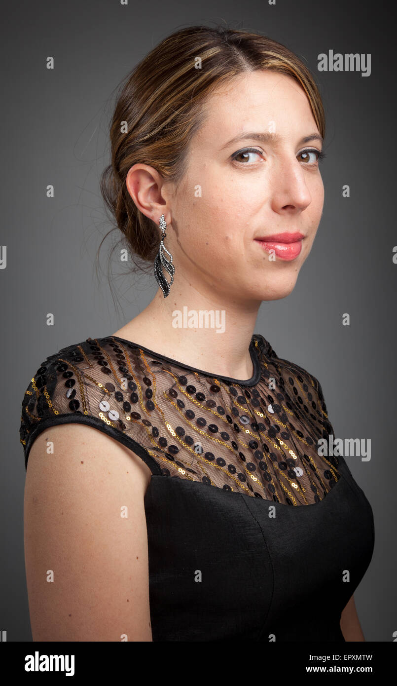 Attractive caucasion girl wearing an evening gown in her 30s shot in studio isolated on a grey background Stock Photo