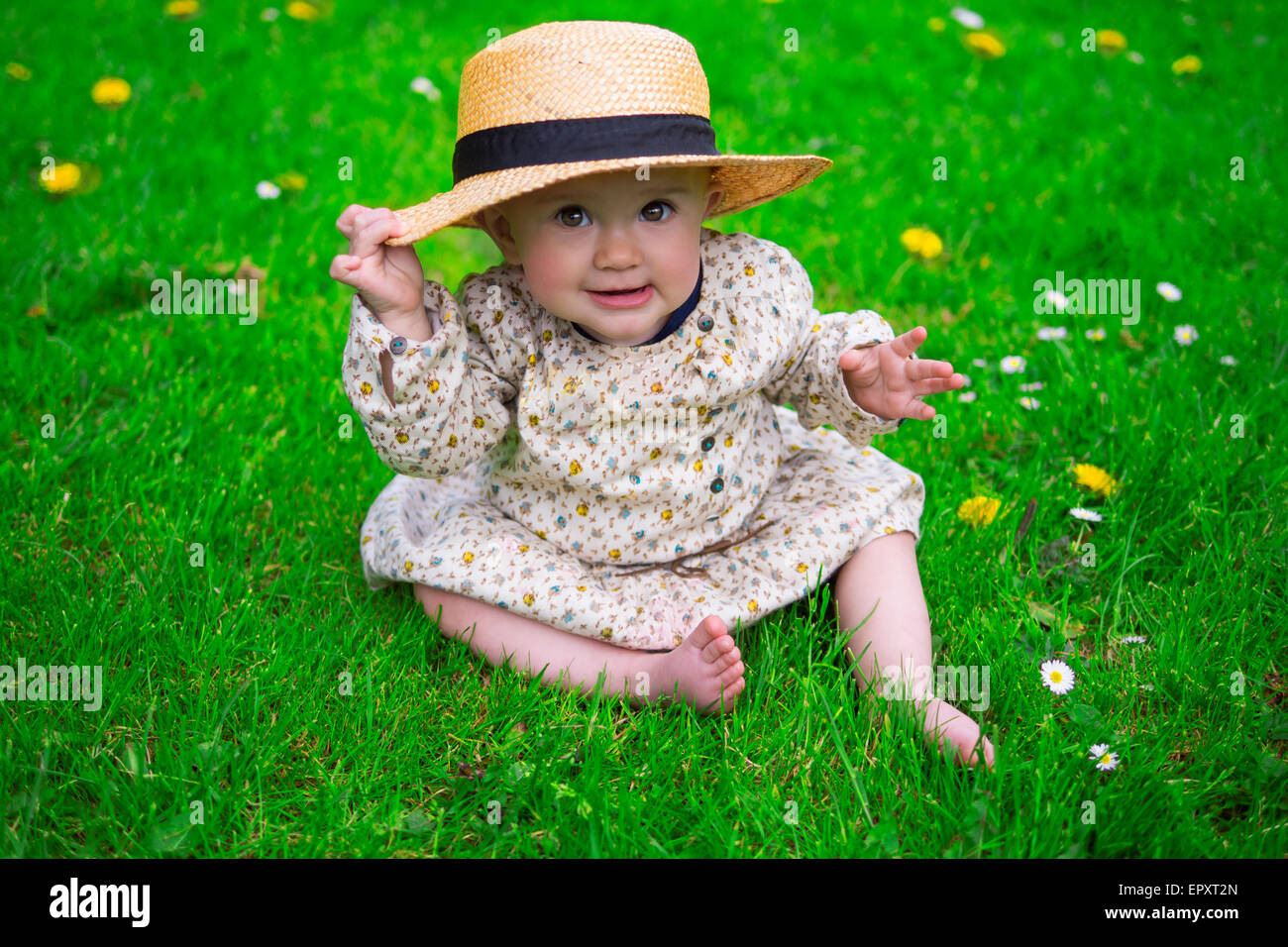 Beautiful baby girl wearing a sun hat in the park Stock Photo