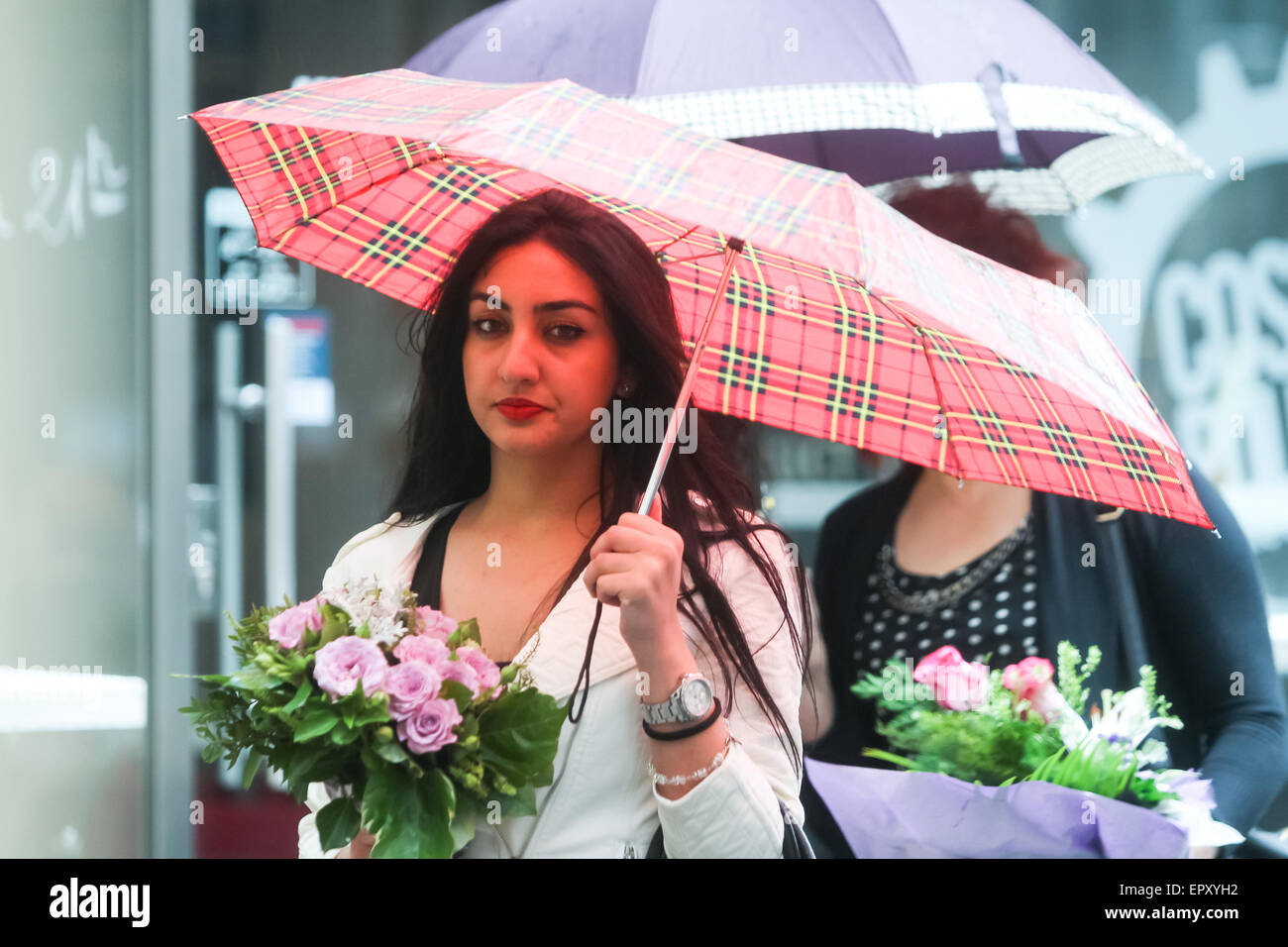 Zagreb, Croatia. 22nd May, 2015. A rainy and windy weather on the street of the city center on May 22, 2015 in Zagreb, Croatia. A young woman with an umbrella holding a posy in the street. Credit:  PhotoJa/Alamy Live News Stock Photo