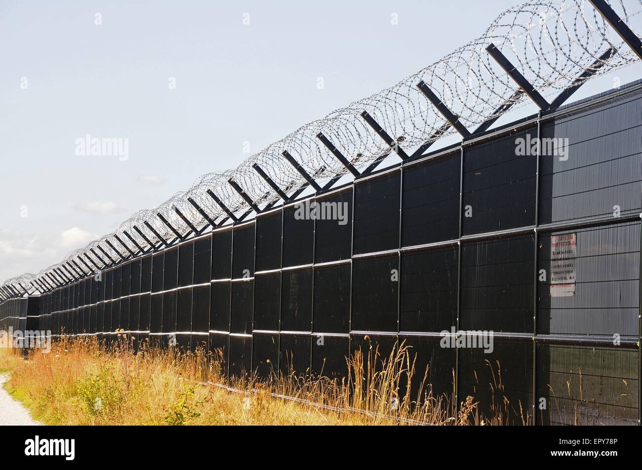 Coiled barbed wire on top of a security fence at Manchester airport, UK