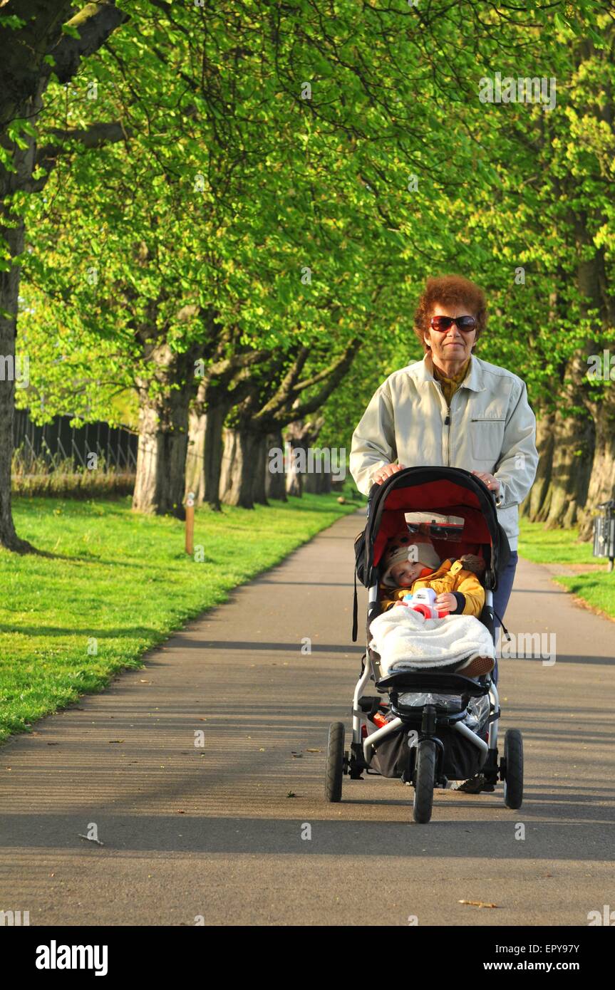 Grandmother and baby in pushchair stroll in the park Stock Photo Alamy