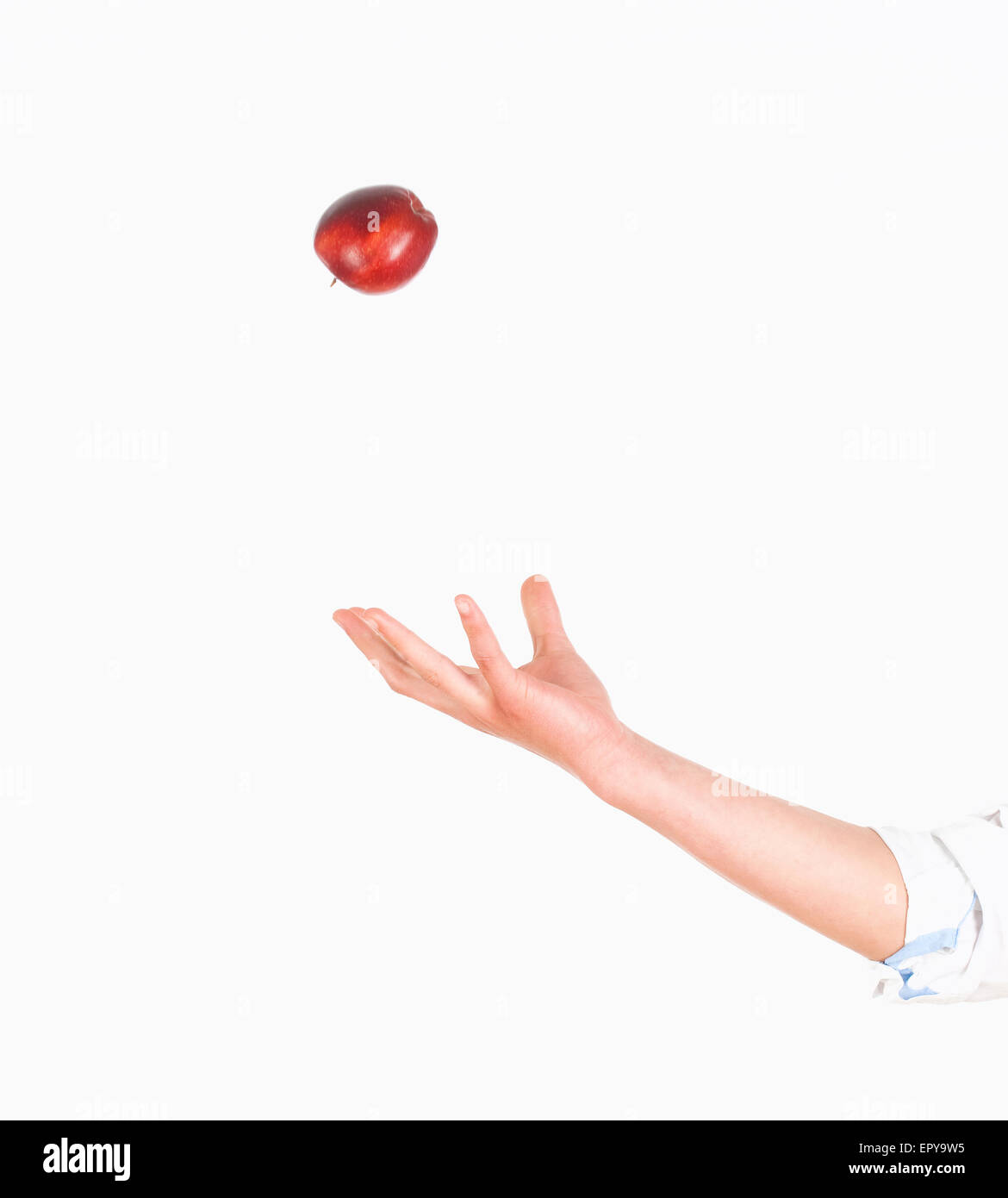 Hand Tossing Red Apple in the Air Stock Photo