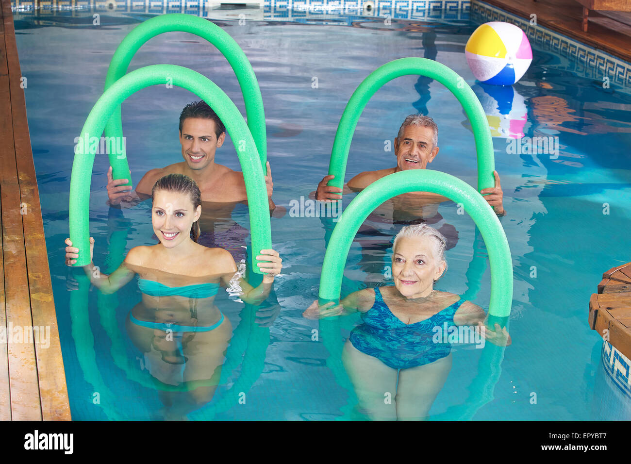 Smiling group doing aqua fitness class together in a swimming pool Stock Photo