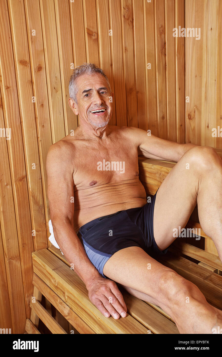 Smiling old man sitting sweating in a sauna in his holidays Stock Photo