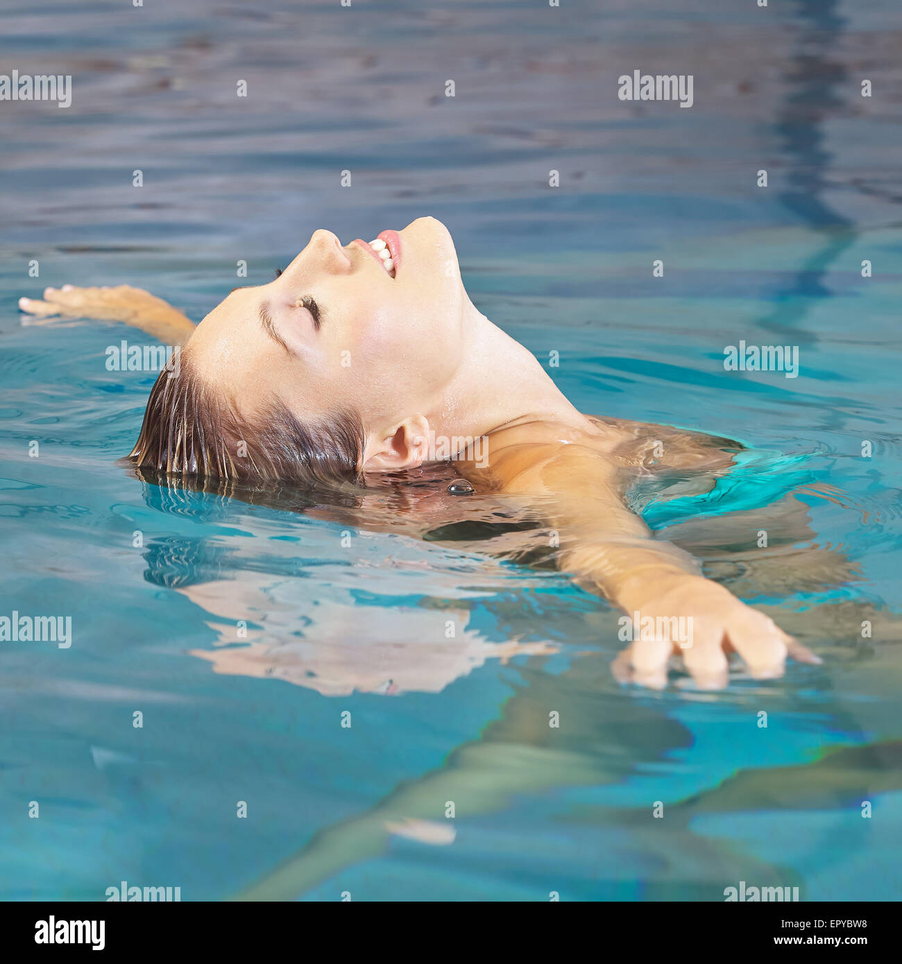Young woman doing water yoga for relaxation in a swimming pool Stock Photo