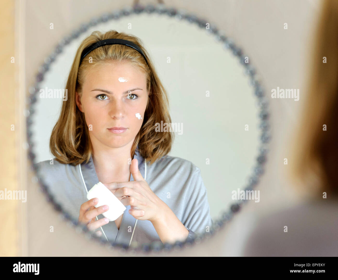 Beautiful young woman applying face cream Stock Photo Alamy