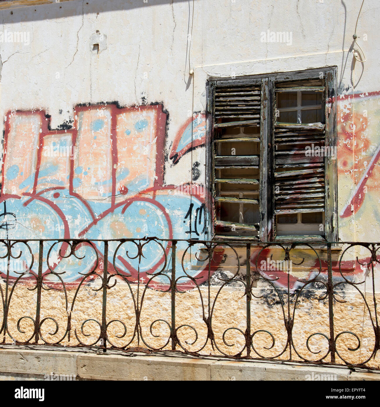 Graffiti painted around window shutters of a derelict house in the