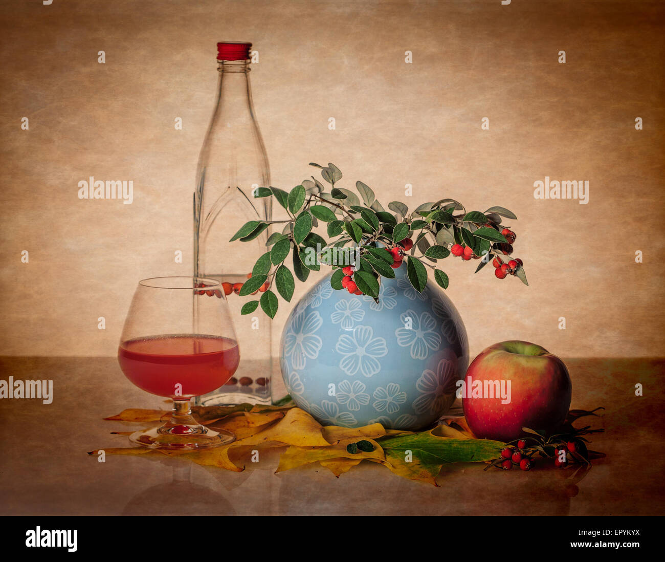 Still life with bottle, glass, and greenery. Stock Photo
