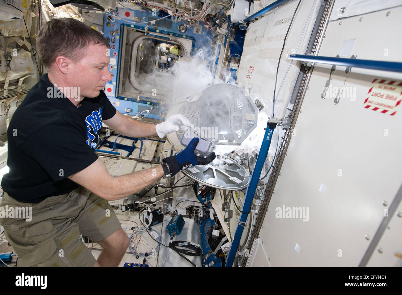 Expedition 43 commander and NASA astronaut Terry Virts prepares the Multi-user Droplet Combustion Apparatus from inside the Combustion Integrated Rack for upcoming runs of the FLame Extinguishment Experiment aboard the International Space Station May 13, 2015 in Earth Orbit. The FLEX-2 experiment studies how quickly fuel burns, the conditions required for soot to form, and how mixtures of fuels evaporate before burning. Stock Photo