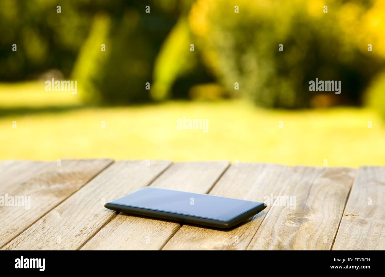 Mobile phone placed on wooden floor with nature background Stock Photo