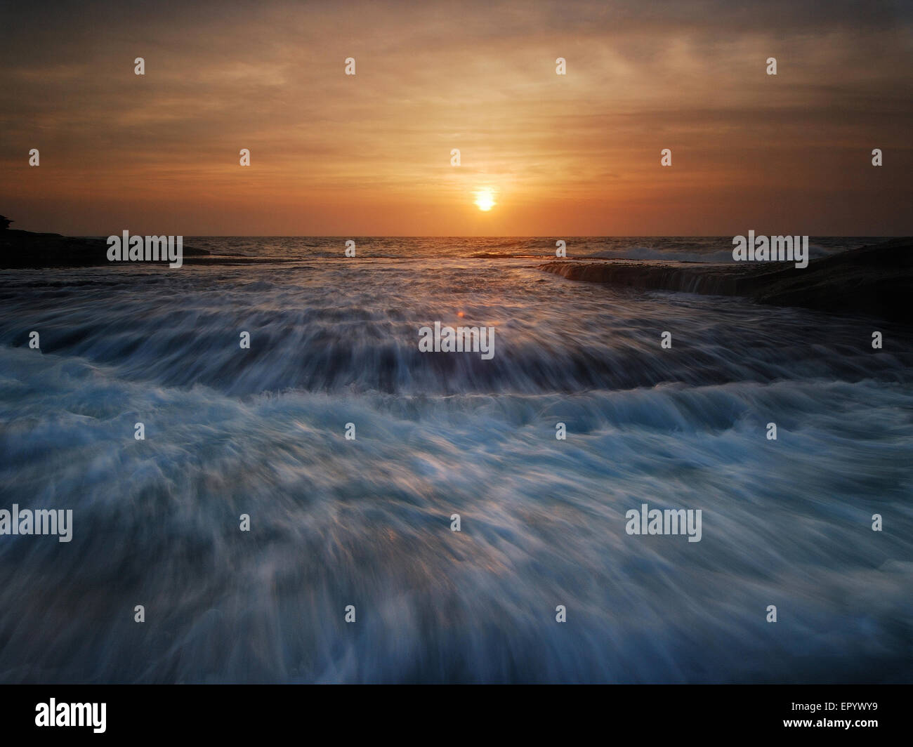 Sunrise seascape with rushing waves Stock Photo