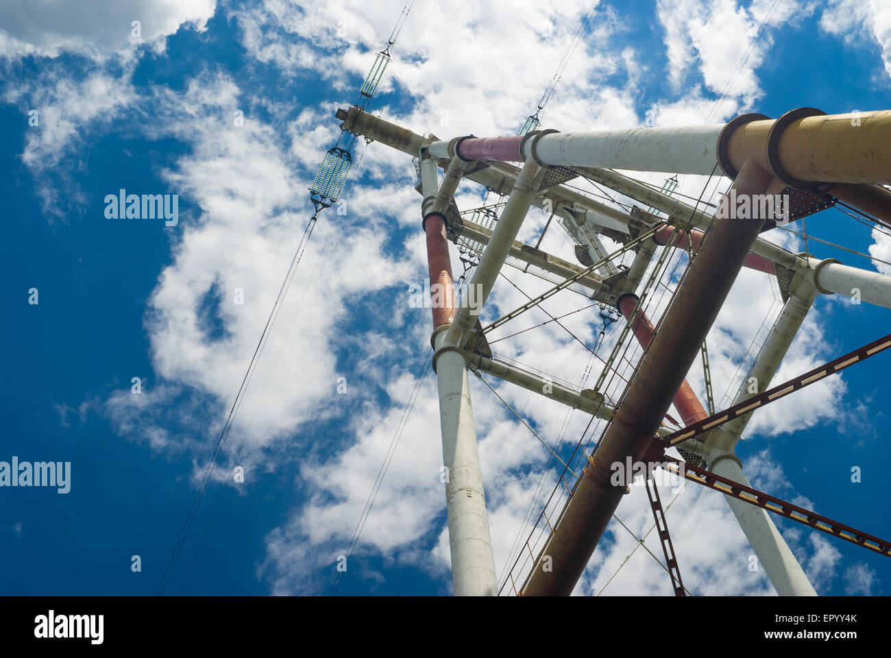 Detail of electricity pylon against blue cloudy sky Stock Photo - Alamy