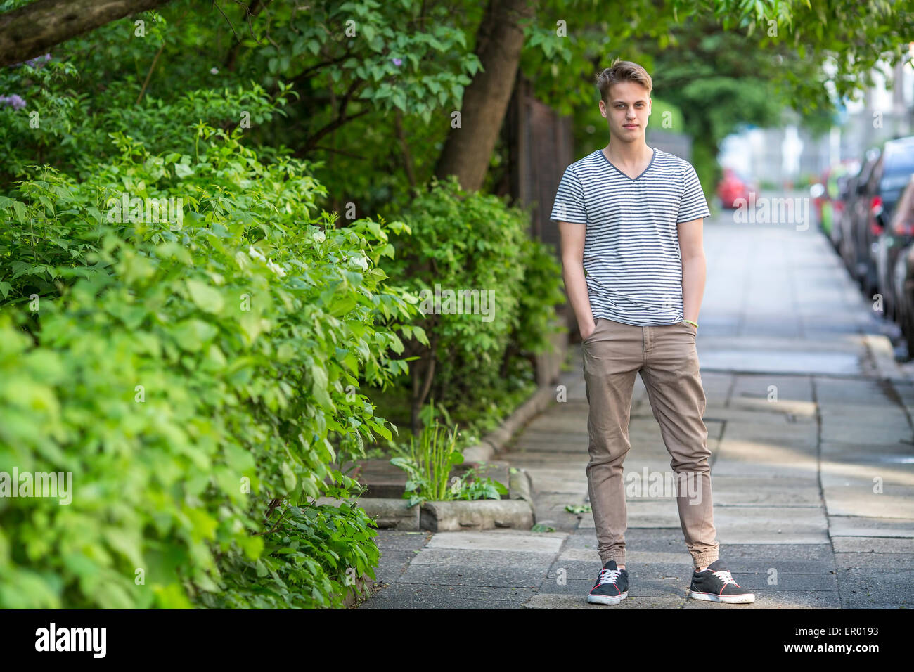 Tall guy standing on the street, a portrait in full growth. Stock Photo