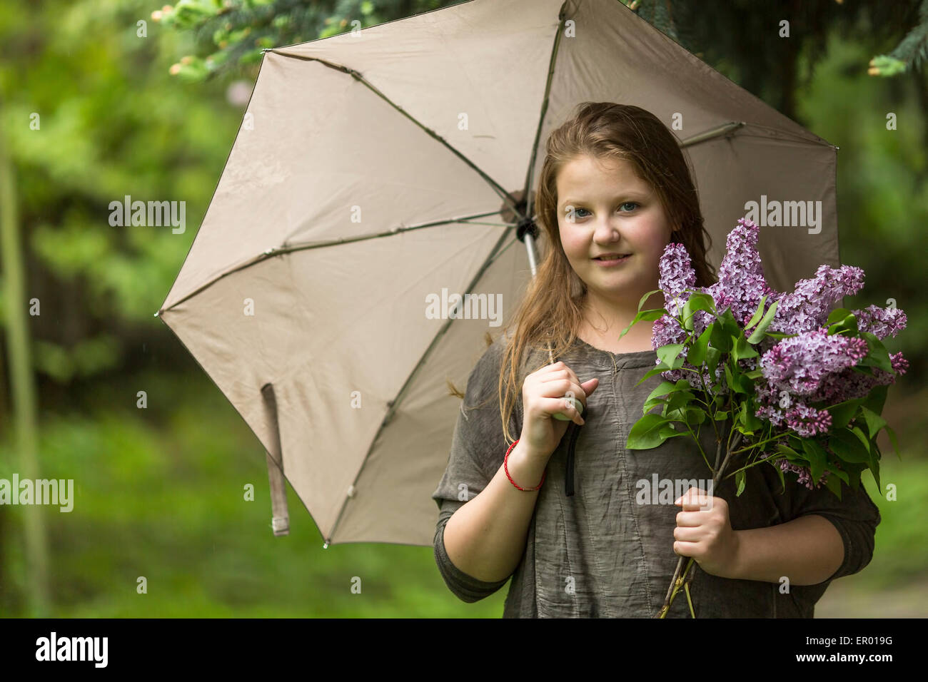 Portrait of teen girl with an umbrella and a bouquet of lilacs Stock ...