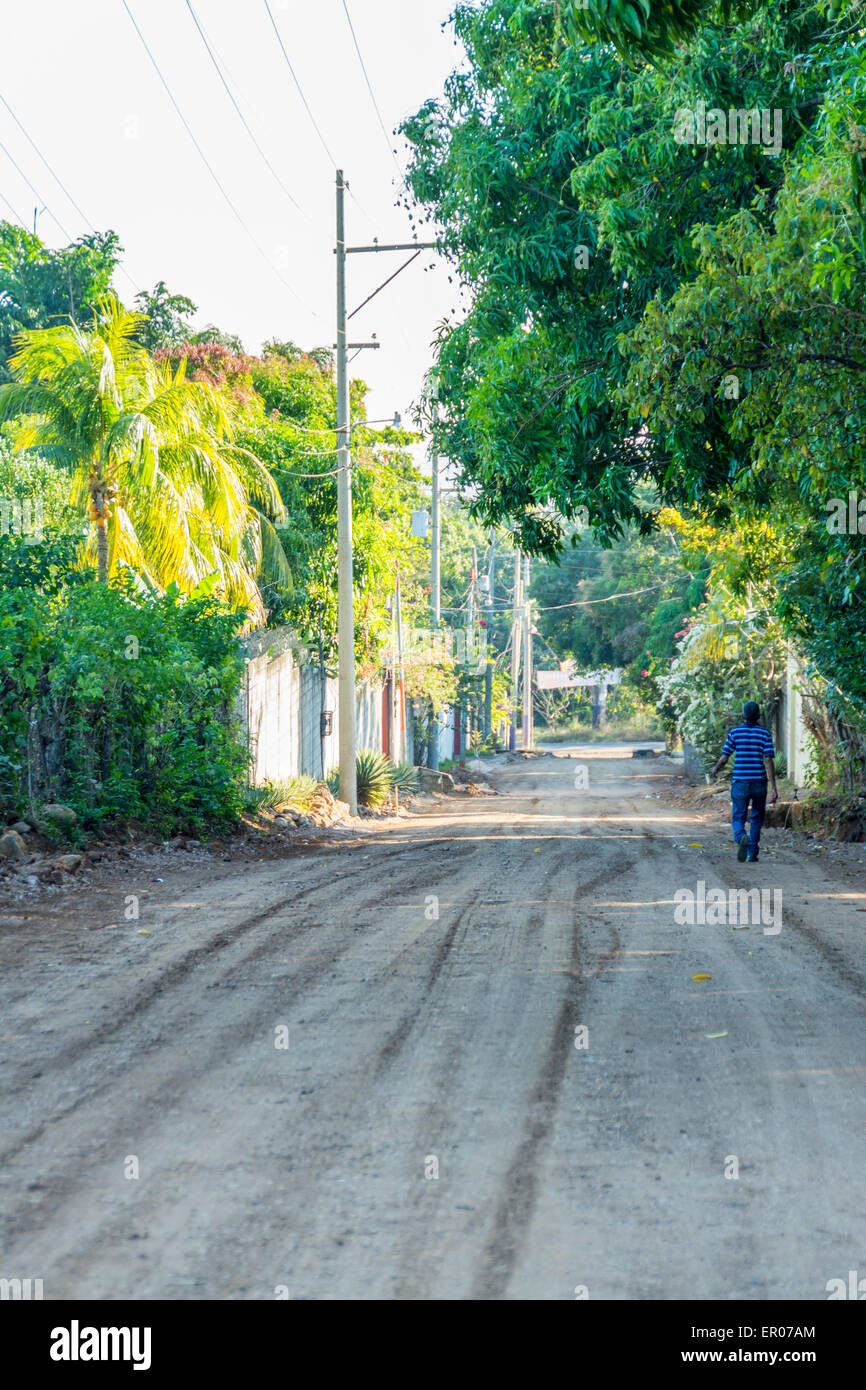 Hispanic man walking down a dirt road in Guazacapan Guatemala Stock Photo