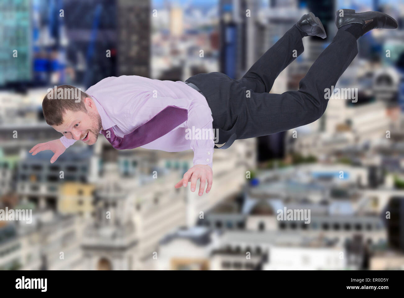 Businessman falling down and modern city in background Stock Photo