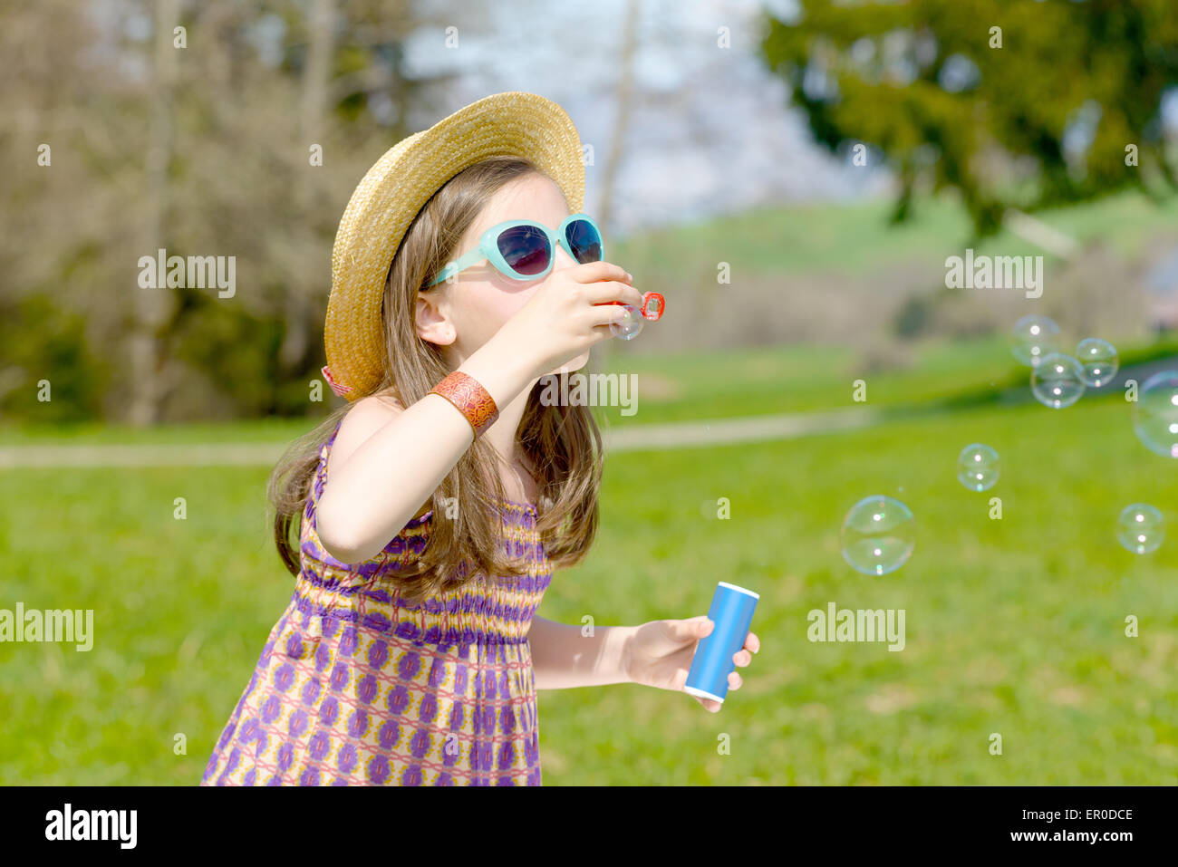 a little girl making soap bubbles with sunglasses in nature Stock Photo ...