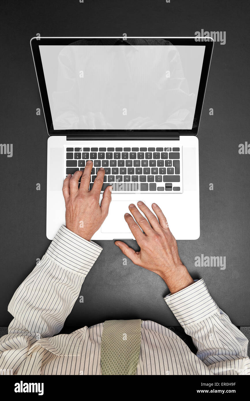 Businessman wearing a white shirt and green tie working on his laptop ...