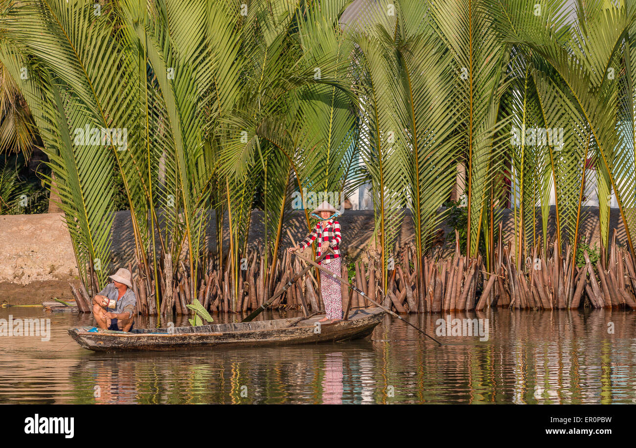 Peasant couple rowing on Mekong river Stock Photo