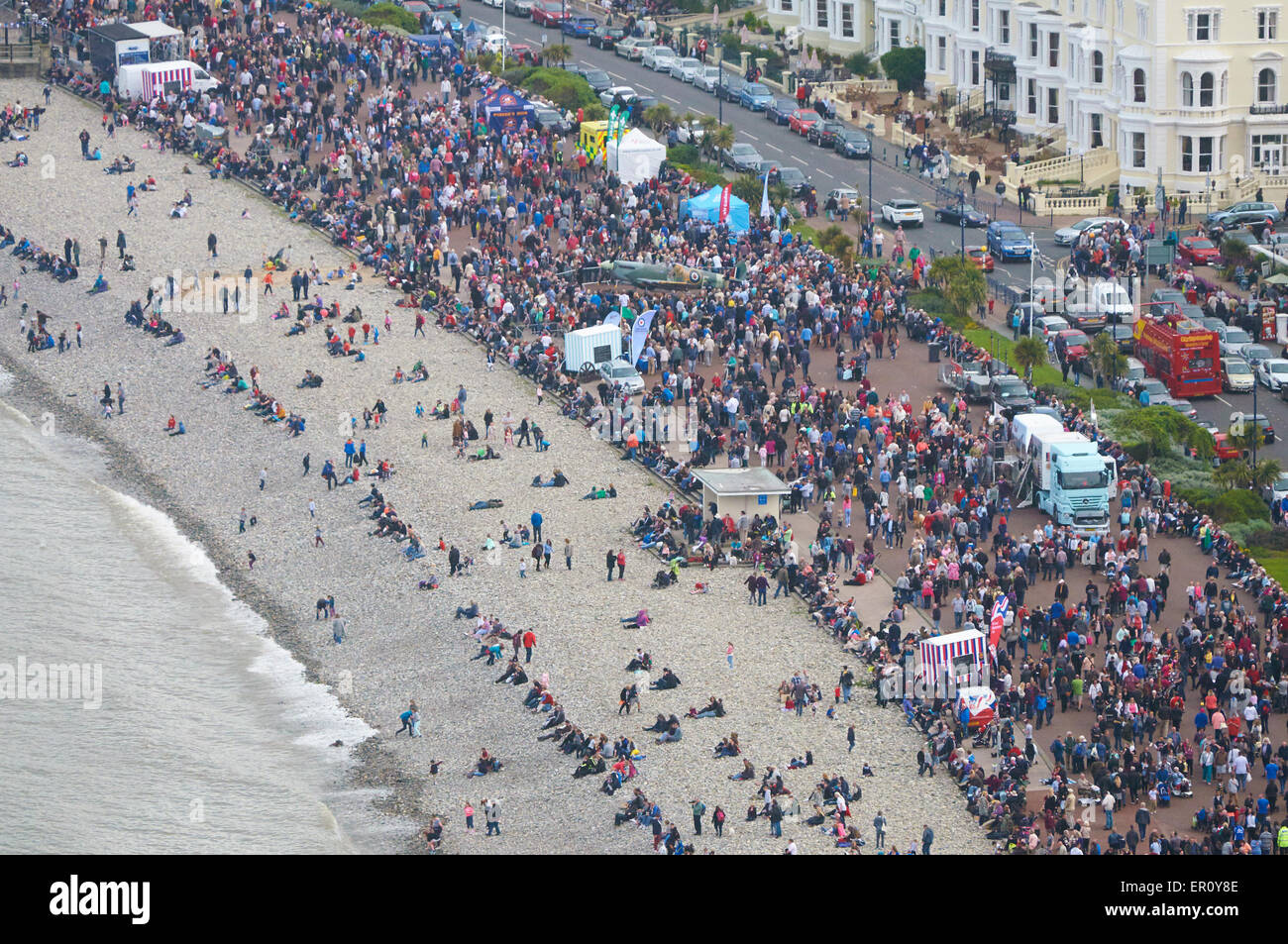 Crowd sitting in a long line along Llandudno East shore beach during Llandudno Airshow Stock Photo